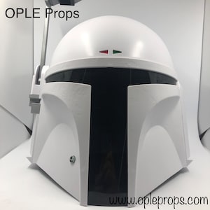 Puede incluir: Casco de Boba Fett de plástico blanco con una visera negra y detalles rojos y verdes. El casco tiene el texto "OPLE Props" y "www.opleprops.com" en él.