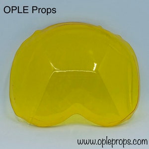 Può includere: Uno schermo facciale in plastica gialla con una forma curva. Lo schermo è progettato per proteggere gli occhi e il viso da schizzi e detriti.