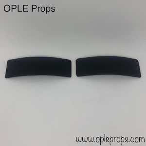 Könnte beinhalten: Zwei schwarze, gebogene, rechteckige Schaumstoffstücke. Die Schaumstoffstücke sind in Größe und Form ähnlich. Der Text "OPLE Props" befindet sich oben im Bild. Der Text "www.opleprops.com" befindet sich unten im Bild.