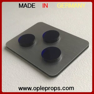 Könnte beinhalten: Eine rechteckige Metallplatte mit drei dunkelblauen kreisförmigen Objekten. Die Platte hat eine gebürstete Metalloberfläche und einen schwarzen Rand. Der Text "MADE IN GERMANY" steht oben. Die Website-Adresse www.opleprops.com steht unten.