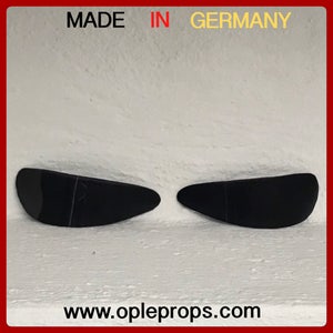 Pode incluir: Dois adereços de plástico preto em forma de olho, feitos na Alemanha, para uso em fantasias ou adereços. O site www.opleprops.com é impresso abaixo dos adereços.