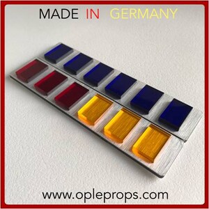 May include: Two rows of colored rectangular buttons on a silver background. The top row has blue buttons and the bottom row has red, yellow, and orange buttons. The text "MADE IN GERMANY" is at the top of the image and "www.opleprops.com" is at the bottom.