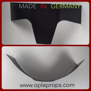Könnte beinhalten: Schwarzer Plastik-Requisit für ein Filmset, geformt wie ein gekrümmtes, umgekehrtes U. Die Requisite ist in Deutschland hergestellt und hat die Website www.opleprops.com aufgedruckt.