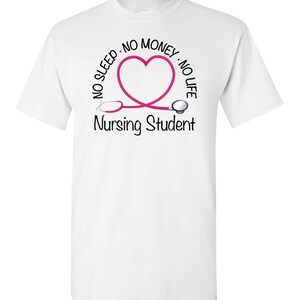 Peut inclure: T-shirt blanc avec un motif de st&eacute;thoscope rose en forme de c&oelig;ur. Le texte autour du c&oelig;ur indique "NO SLEEP - NO MONEY - NO LIFE". En dessous, le texte "Nursing Student" est imprim&eacute; en noir.