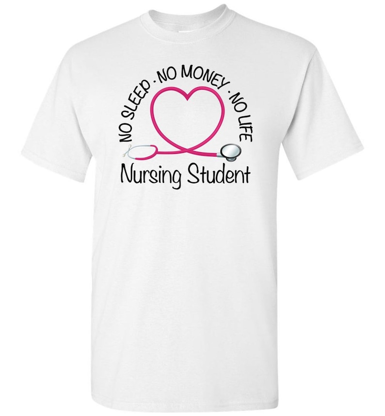 Peut inclure: T-shirt blanc avec un motif de st&eacute;thoscope rose en forme de c&oelig;ur. Le texte autour du c&oelig;ur indique "NO SLEEP - NO MONEY - NO LIFE". En dessous, le texte "Nursing Student" est imprim&eacute; en noir.