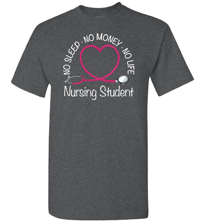 Peut inclure: T-shirt gris fonc&eacute; avec un motif de st&eacute;thoscope rose en forme de c&oelig;ur. Le texte indique "NO SLEEP - NO MONEY - NO LIFE" autour du c&oelig;ur, avec "Nursing Student" en dessous. Un t-shirt d&eacute;contract&eacute; pour &eacute;tudiants.