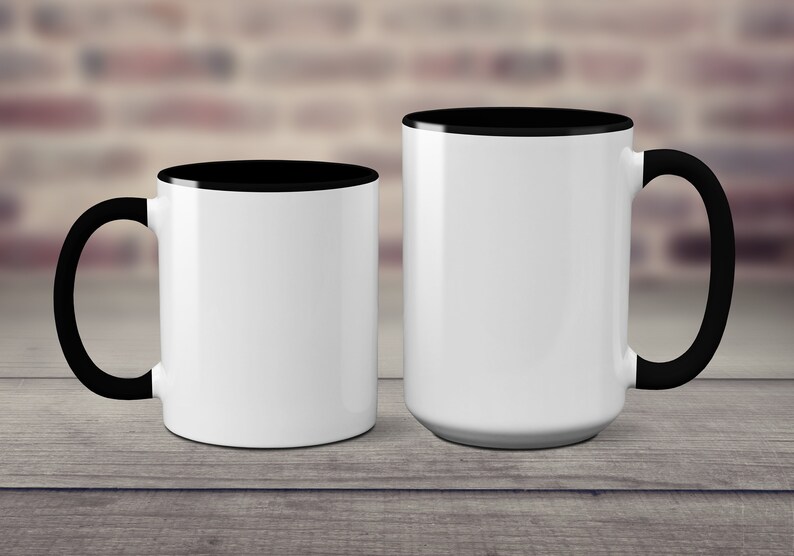 May include: Two white ceramic mugs with black rims and handles. The mug on the left is smaller than the mug on the right.