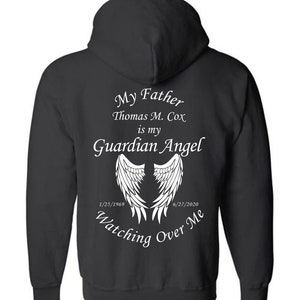 May include: Black zippered hoodie with white text that reads "My Father Thomas M. Cox is my Guardian Angel" with angel wings and dates "1/25/1969" and "6/27/2020" and the text "Watching Over Me".