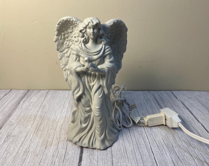 White ceramic angel holding a dove that lights up