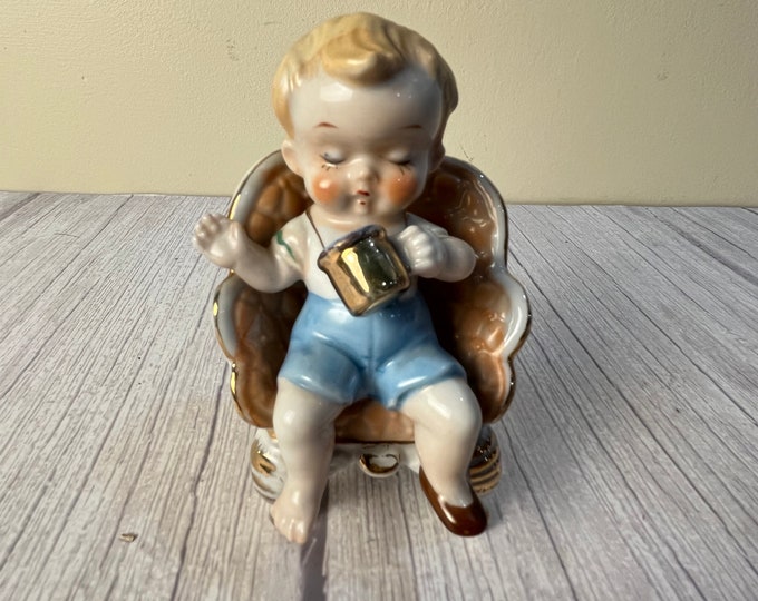 Little boy sitting in chair with gold cup from Japan