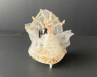 Vintage Plastic Bride & Groom Cake Topper surrounded with White tulle, Lily of Valley floral sprays on Heart shaped base