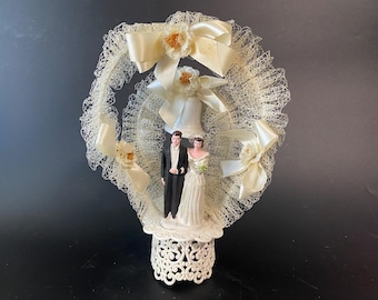 Vintage Double Laced Arch with Plaster Bride and Groom Cake Topper with bows and bell