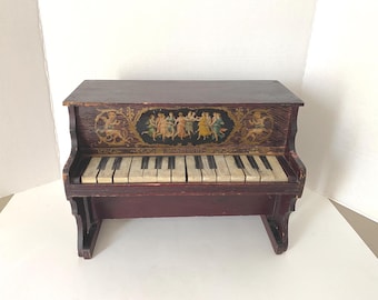 Late 1800s-Early 1900s Wooden Schoenhut Toy Piano features 14 keys and a  beautiful lithograph image of dancing women and cherubs