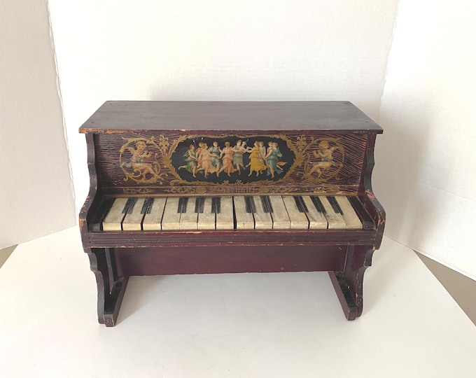 Late 1800s-Early 1900s Wooden Schoenhut Toy Piano features 14 keys and a  beautiful lithograph image of dancing women and cherubs