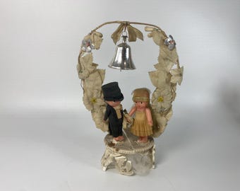 1930s Celluloid Kewpie Bride and Groom Cake Topper on Plaster Base with Floral Arch and Bell