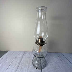 male 12 panel with decorative scrolling clear glass oil lamp with beaded chimney and wick.