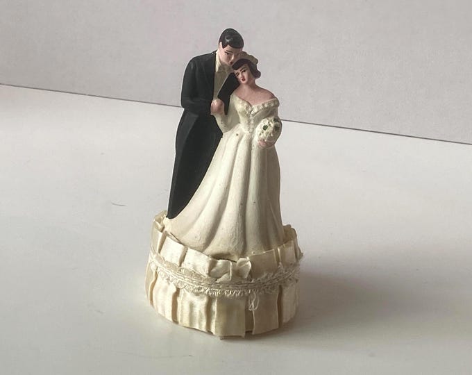 1950s-1960s Vintage Bride Resting her head on her Groom Chalkware Wedding Cake Topper standing on satin pleated base