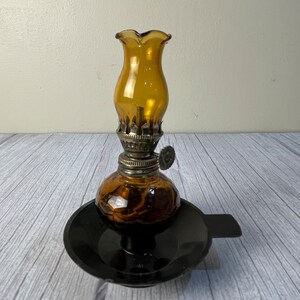 Amber Home Decorative Product # 1967 miniature oil Lamp with scalloped amber chimney and wick on black plastic base with tab