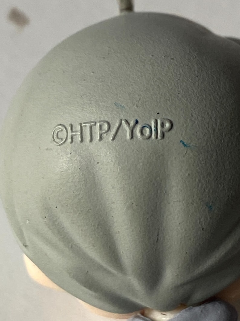 May include: Close-up of a gray, rounded object with the text "&copy;HTP/YoIp" imprinted on its surface. The object has a textured appearance and appears to be made of a matte material. The overall shape is smooth and slightly irregular.