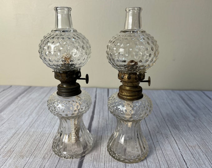 Vintage pair of small clear glass hob knob oil lamps with chimneys and wicks