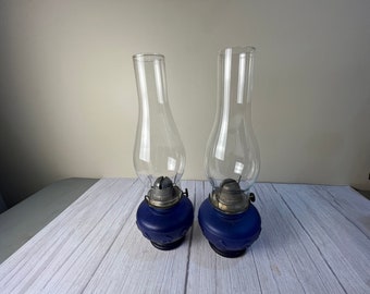 Pair of "rare Frosted Cobalt blue color oil lamp with a center wide band raised spade leaf design. Tiered step stem base