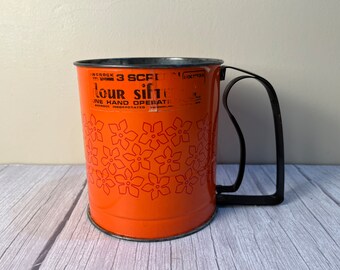 Vintage Androck orange painted flour sifter