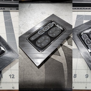 May include: A black control panel with a silver trim and the text "E-Level" printed on it. The panel has several buttons with arrows pointing in different directions.