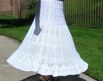 May include: A white crochet skirt with a delicate lace pattern. The skirt is long and flowing, with a ruffled hem.