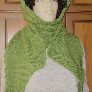 May include: A green knitted scarf with a hood. The scarf is made of a soft, textured yarn and has a simple, elegant design.