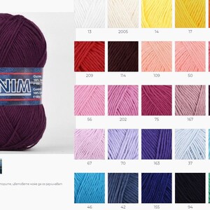May include: A ball of deep purple yarn with the word "DENIM" printed on the label. The yarn is 100% cotton and is part of a collection of yarn colors.