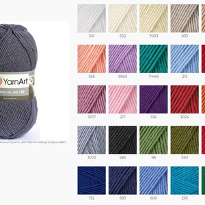 May include: A skein of YarnArt Merino de Luxe 150 yarn in a dark gray color. The yarn is displayed on a white background with a color chart of different yarn colors.