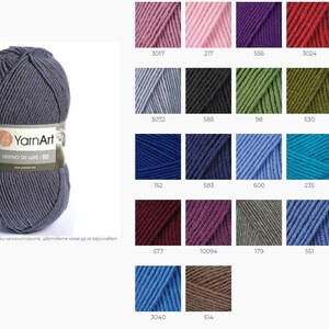 May include: A skein of dark gray yarn labeled "YarnArt Merino De Luxe/50". A color chart shows 16 different yarn colors, including pink, purple, green, blue, and brown.
