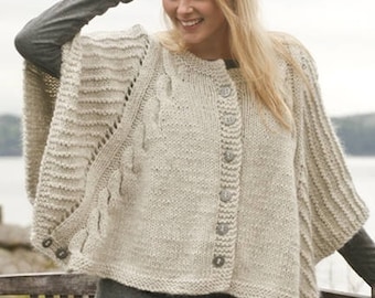 May include: A beige knit poncho featuring a vertical cable knit pattern, a button-down front closure with five round buttons, and additional buttons at the side seams. The garment is crafted from a textured yarn with a visible knit stitch pattern.