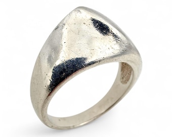May include: A silver-toned ring with a triangular face. The ring has a smooth, polished finish with some visible wear and scratches. The band is rounded and tapers towards the back.