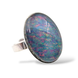 May include: A silver ring with an oval opal. The opal has a colourful display of blues, greens, pinks, and purples. The ring's band is adjustable.