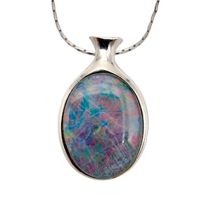 Könnte beinhalten: Silberne Anhängerkette mit einem ovalen Opal-Edelstein. Der Opal zeigt eine Mischung aus Farben, darunter Blau, Lila und Grün. Der Anhänger hat eine einzigartige, längliche Form mit einer Silberkette.