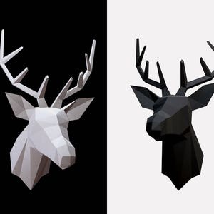 May include: A white and a black geometric deer head sculpture. Both deer heads are made of triangles and have antlers.