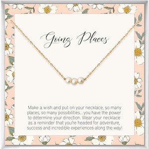 May include: A gold necklace with three white pearls on a white card with a floral pattern. The card says "Going Places" and includes a message about making a wish and wearing the necklace as a reminder to go on adventures.