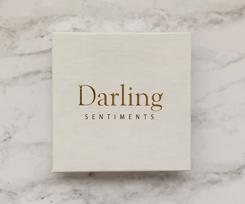 May include: A white box with the words "Darling Sentiments" printed in gold lettering.