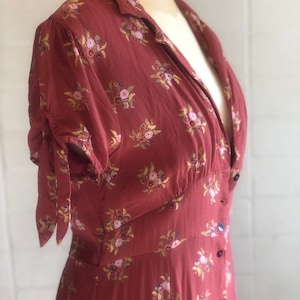 Peut inclure: Une robe &agrave; fleurs rouge &agrave; col en V, manches courtes et fermeture boutonn&eacute;e.