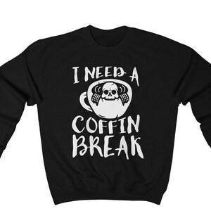 May include: Black sweatshirt with white text that reads "I need a coffin break" and a graphic of a coffee cup with a skull inside.