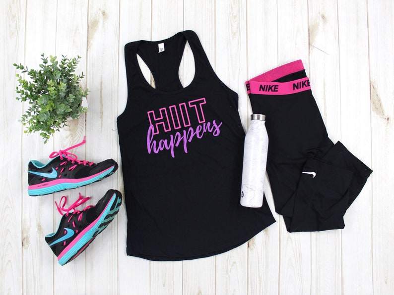 May include: Black tank top with the text "HIIT happens" in pink and purple lettering. The tank top is paired with black leggings with a pink Nike logo waistband, black and blue running shoes, and a white water bottle.