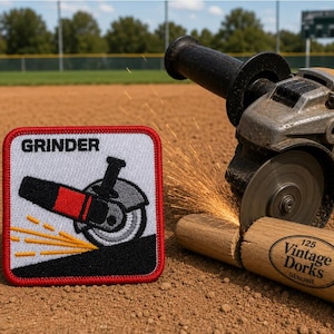 May include: A square embroidered patch with a red border featuring a white background, the word GRINDER in black, and a graphic of an angle grinder cutting metal with orange sparks. The patch is displayed next to a real angle grinder in use.