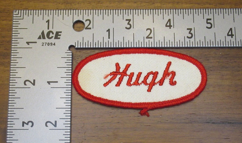 faded work uniform patch with Hugh in red stitching Hugh white