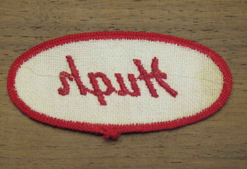 faded work uniform patch with Hugh in red stitching Hugh white