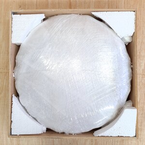 Pu&ograve; includere: Un oggetto rotondo e bianco avvolto in plastica trasparente &egrave; accuratamente confezionato in una scatola di legno con imbottitura in schiuma.