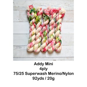 May include: Five skeins of yarn in a white base with pink, green, and yellow speckles. The yarn is labeled "Addy Mini 4ply 75/25 Superwash Merino/Nylon 92yds / 20g".