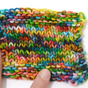Puede incluir: Primer plano de una tela de punto colorida con una variedad de colores, incluyendo verde, azul, amarillo, naranja y rosa.