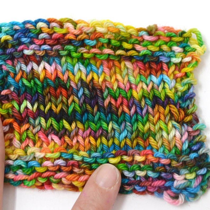 Puede incluir: Primer plano de una tela de punto colorida con una variedad de colores, incluyendo verde, azul, amarillo, naranja y rosa.