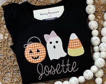 May include: Black Halloween shirt with a ghost, pumpkin, and candy corn design. The shirt says "Midway Monograms & Vinyl Designs" and "Jossette" in white thread.